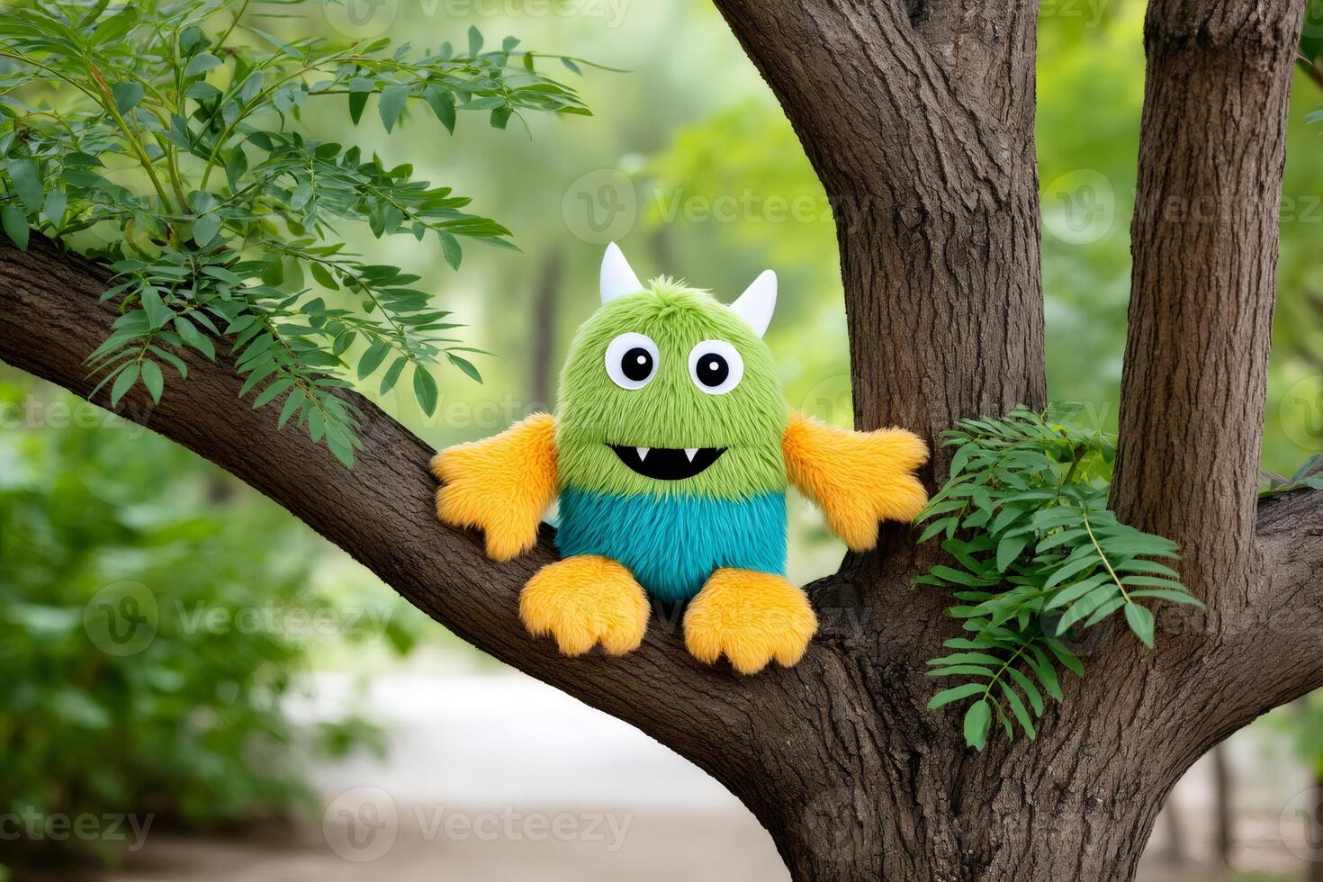 Friendly monster toy sitting on a tree branch in a park photo