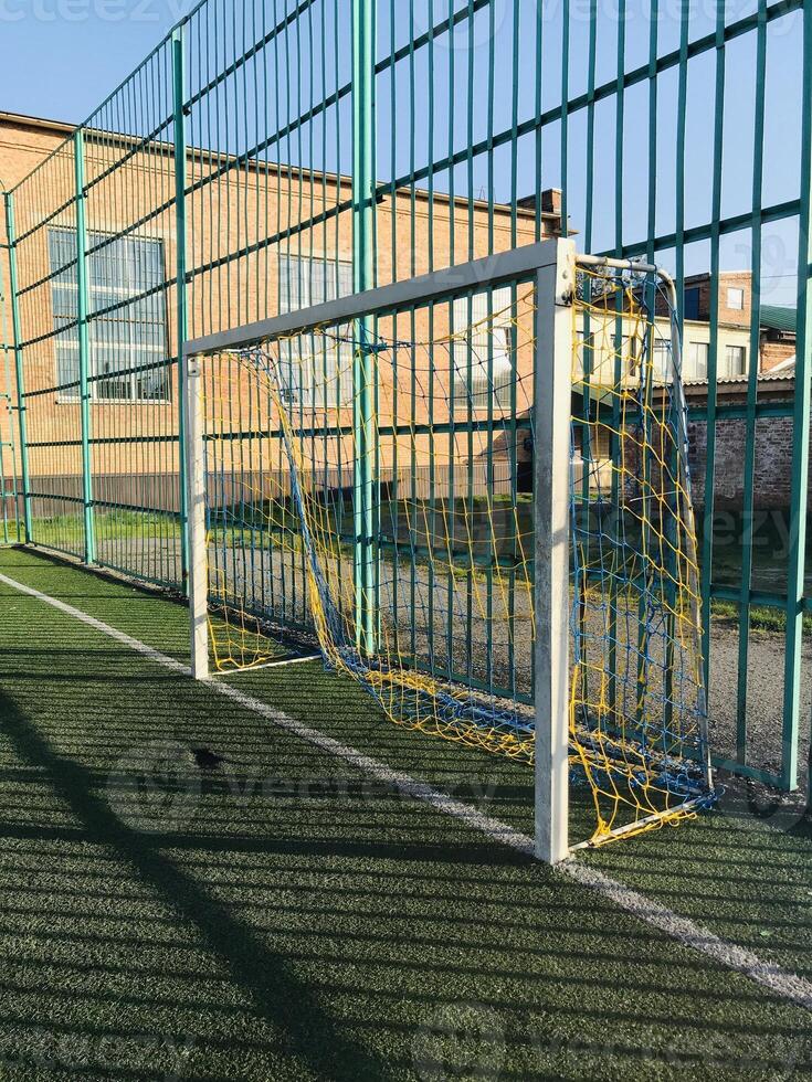 Broken goal net on a sunny day at a local soccer field photo