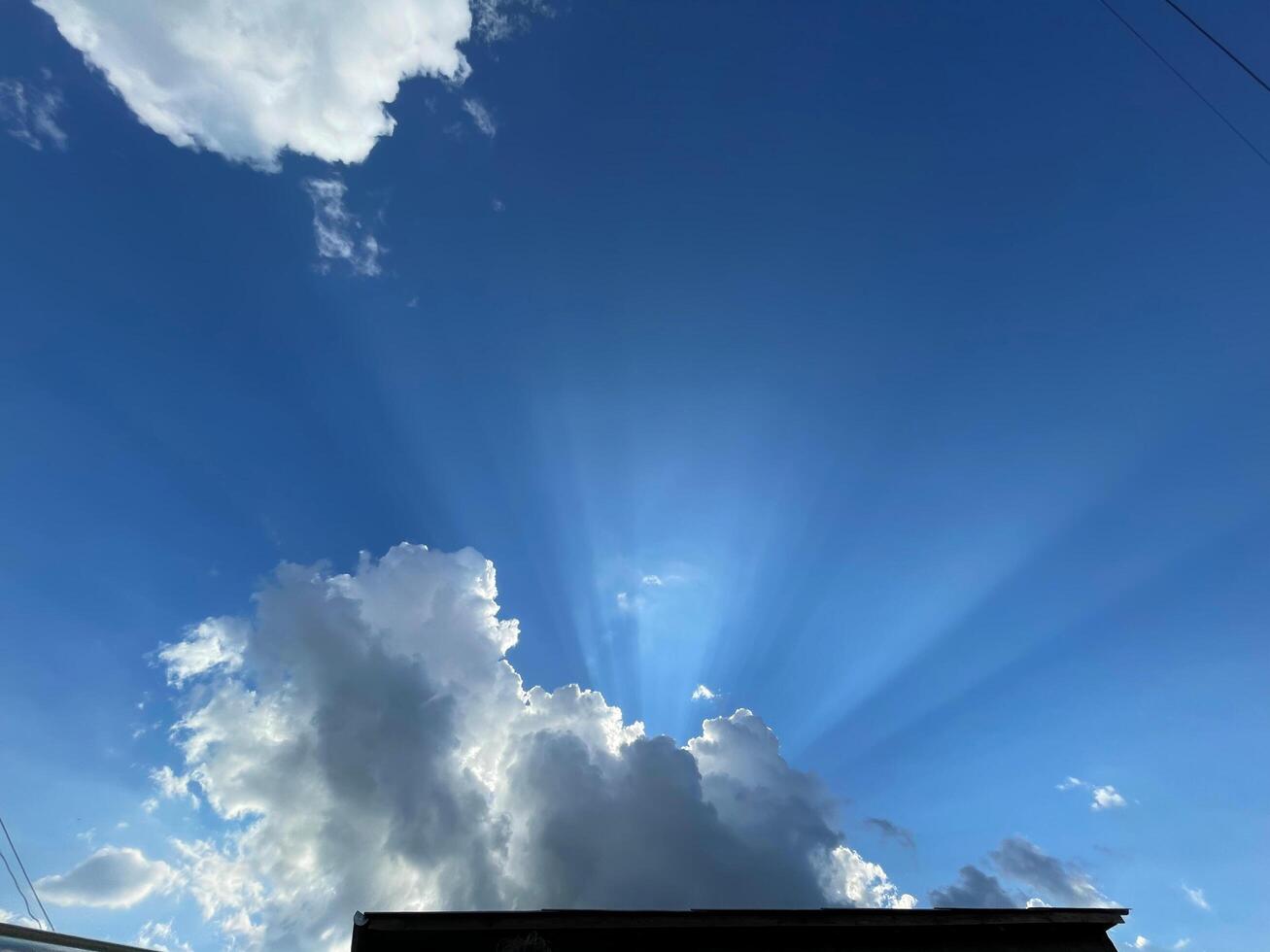 Bright rays of sunlight emerging through fluffy clouds photo