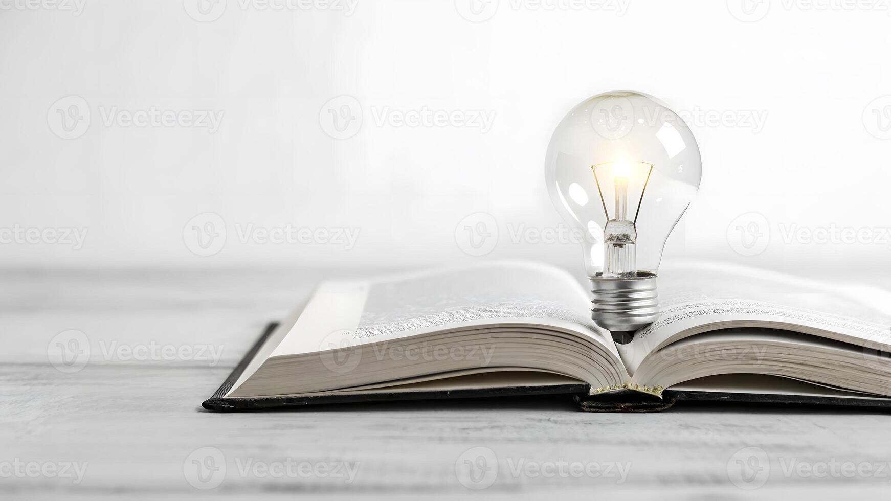 Light bulb resting on open book symbolizing ideas and knowledge discovery photo