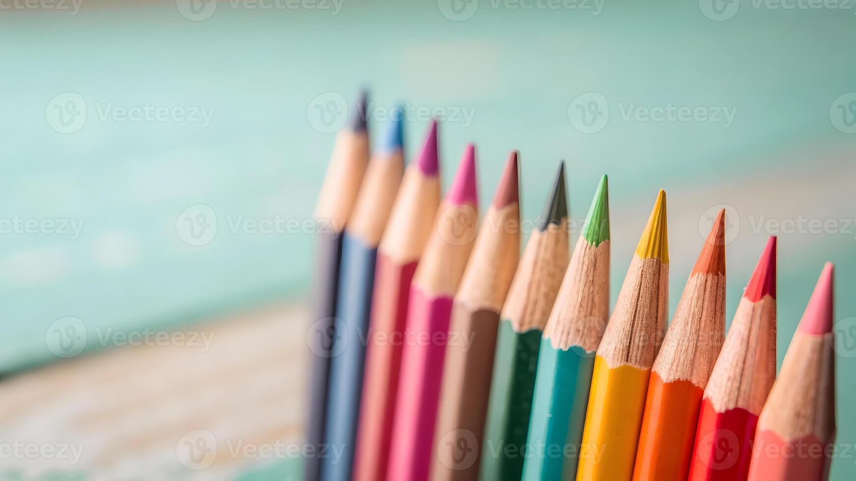 Colorful pencils arranged neatly on wooden surface for creative projects photo