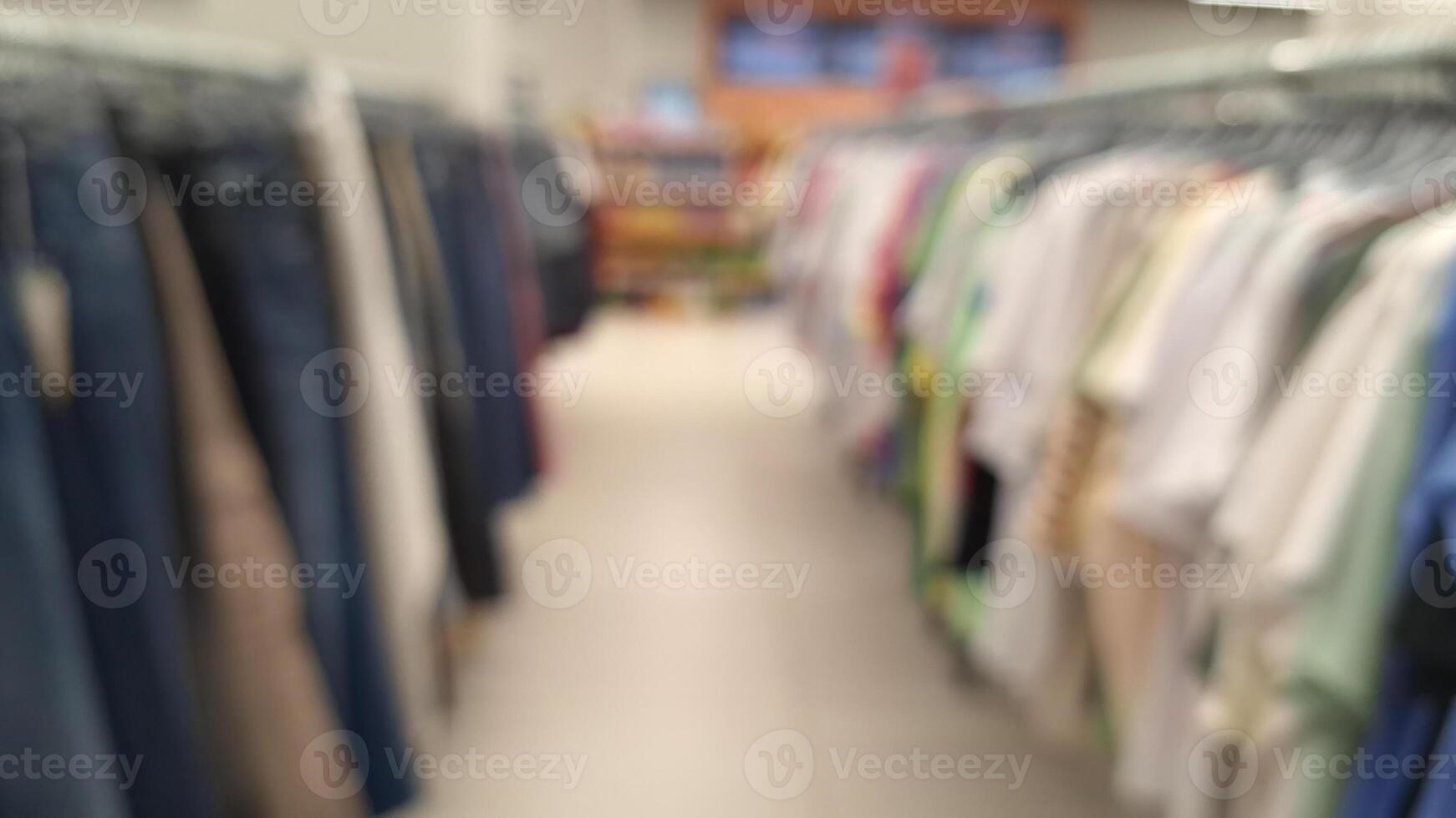 Blurred view of clothing aisle in store with various apparel on racks photo