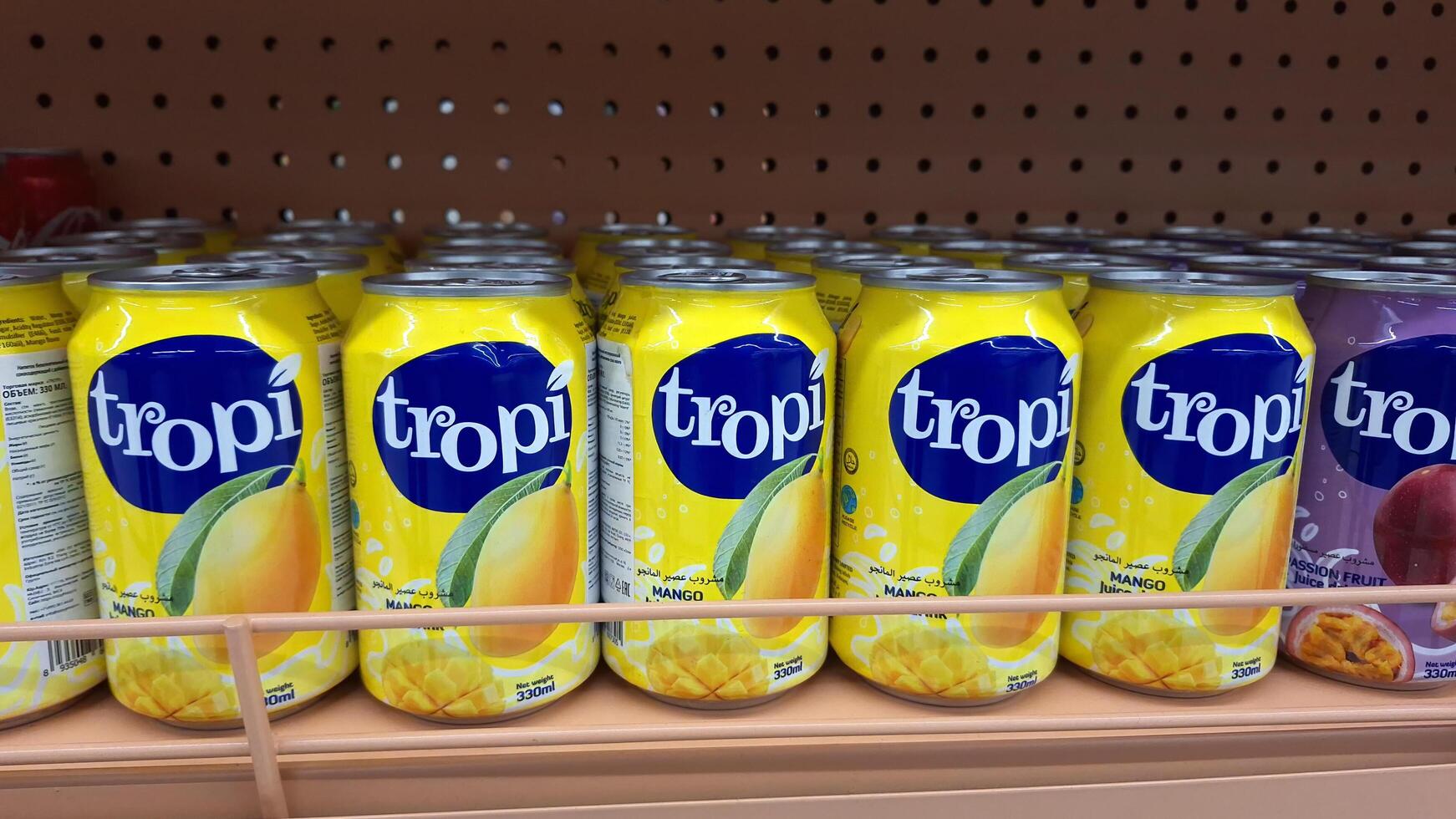 Moscow, Russia - April 26, 2025.Tropical mango flavored beverage Tropi cans on store shelf photo