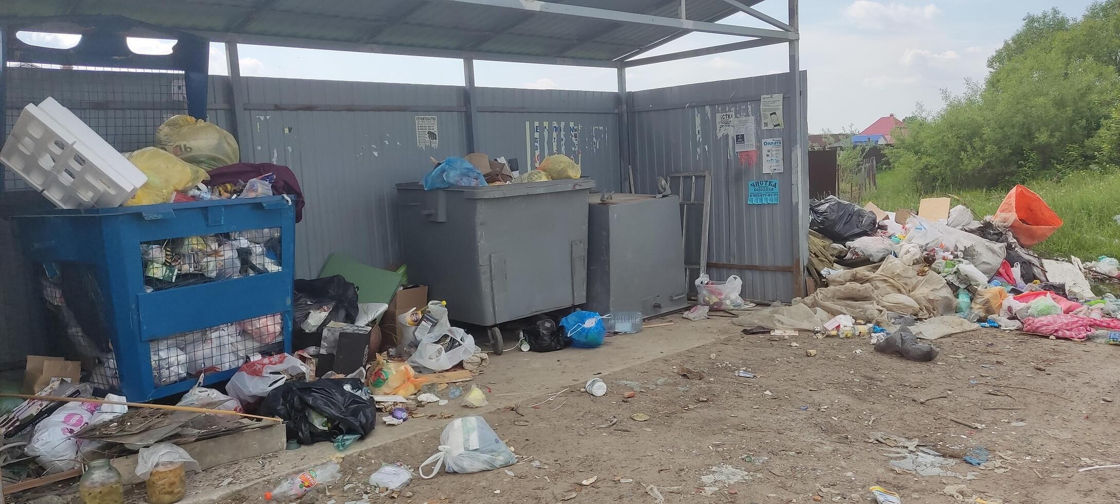 Moscow region, Russia - 10.06.2022.Overflowing garbage area with litter and dumpsters in an outdoor setting photo