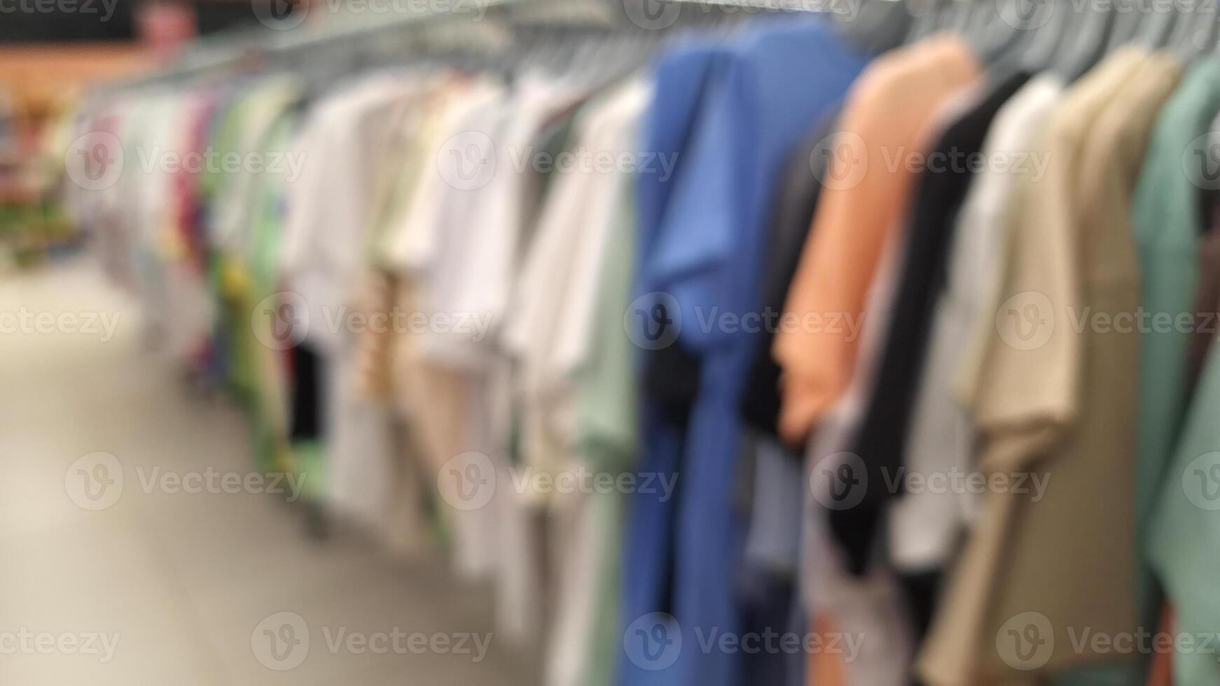 Blurred display of colorful clothing on racks in retail store photo