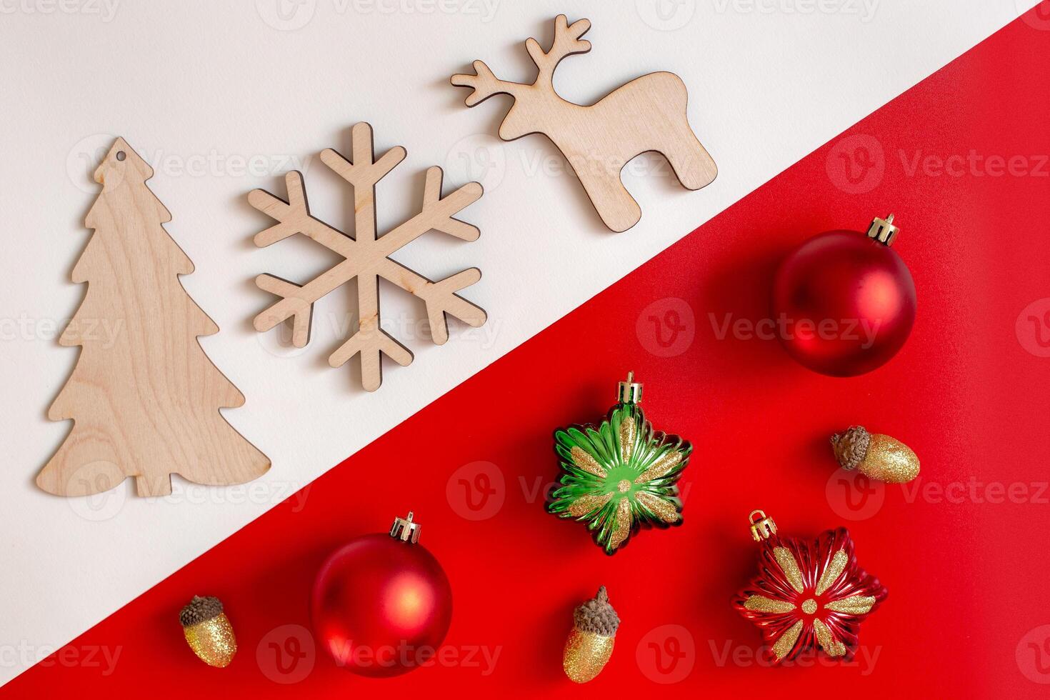 On a diagonal red and white background, flat natural wooden Christmas toys against plastic colored toys. photo