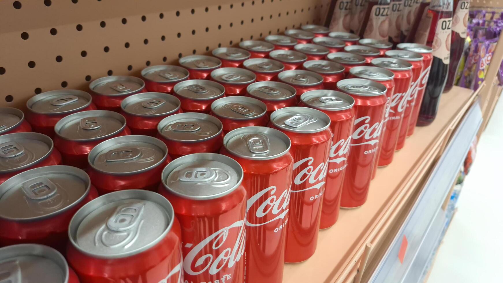 Moscow, Russia - April 26, 2025.Rows of coca-cola cans on store shelf in grocery aisle photo