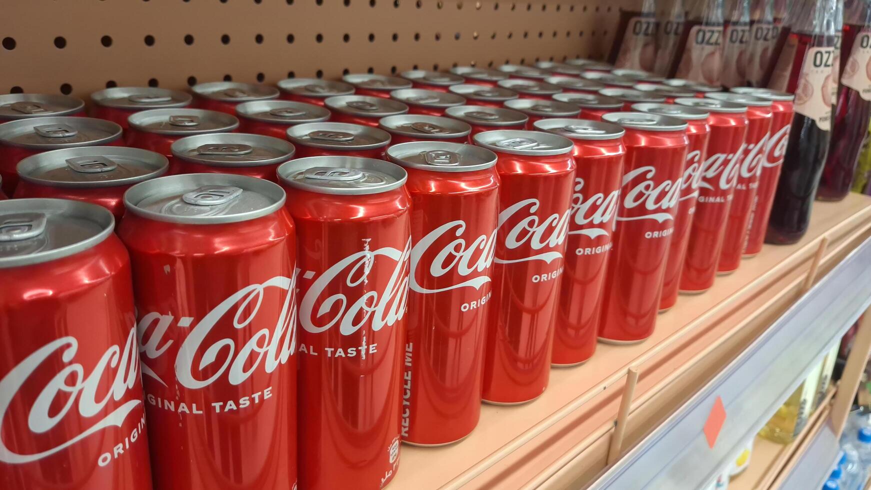Moscow, Russia - April 26, 2025.Rows of coca-cola cans on supermarket shelf photo