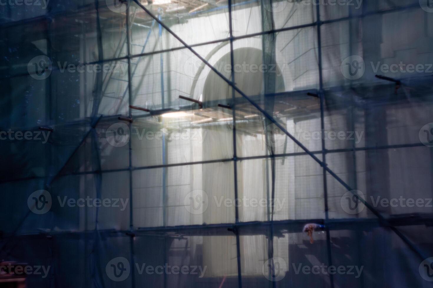 Building under renovation with scaffolding and green netting at night photo