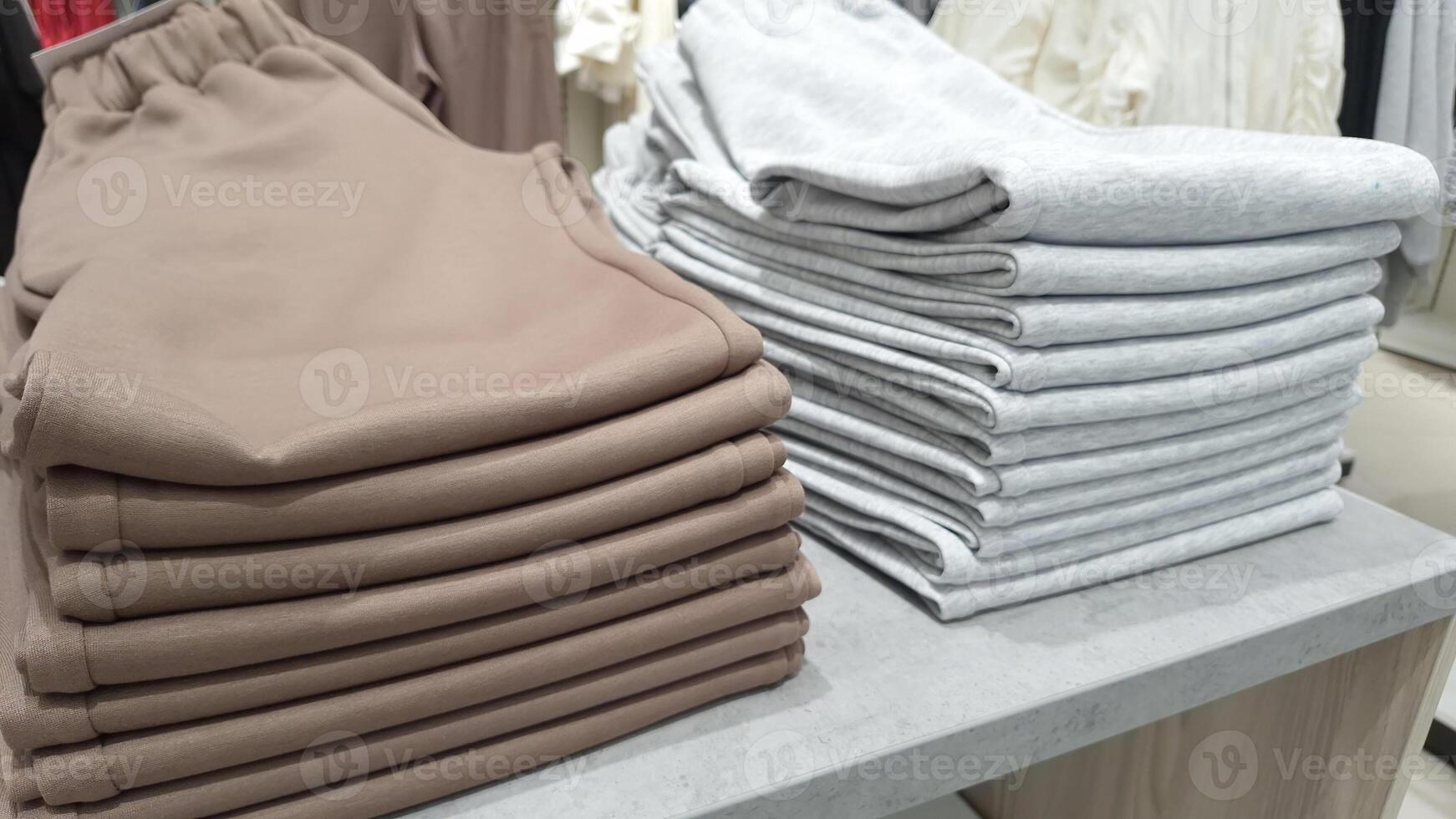 Neatly folded brown and gray sweatpants in retail store display photo