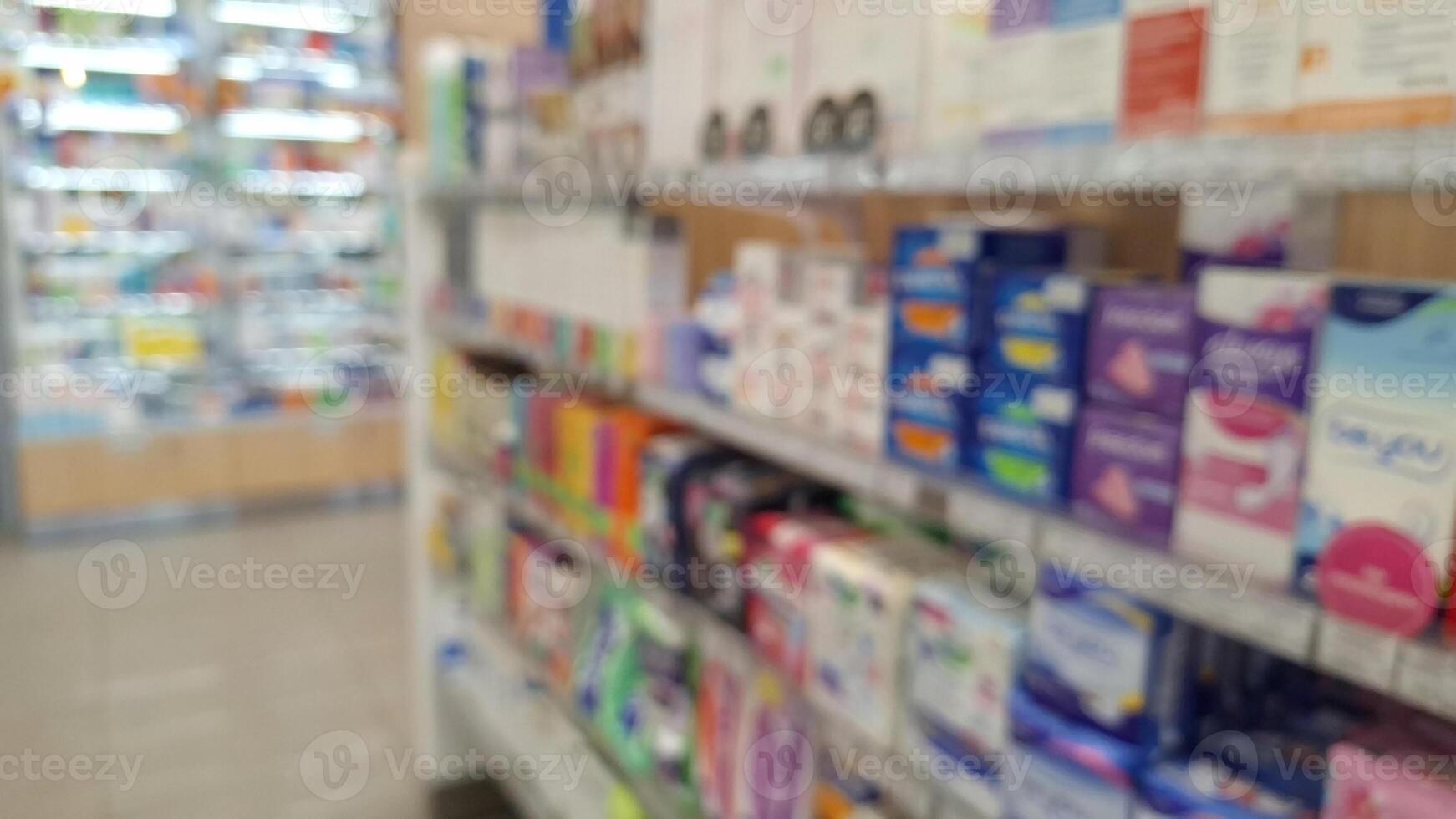 Blurred pharmacy aisle with diverse medicine and health products on shelves photo