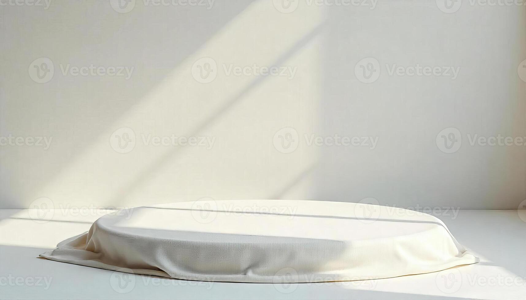A white round podium covered with fabric in a white room with sunlight coming from the window photo