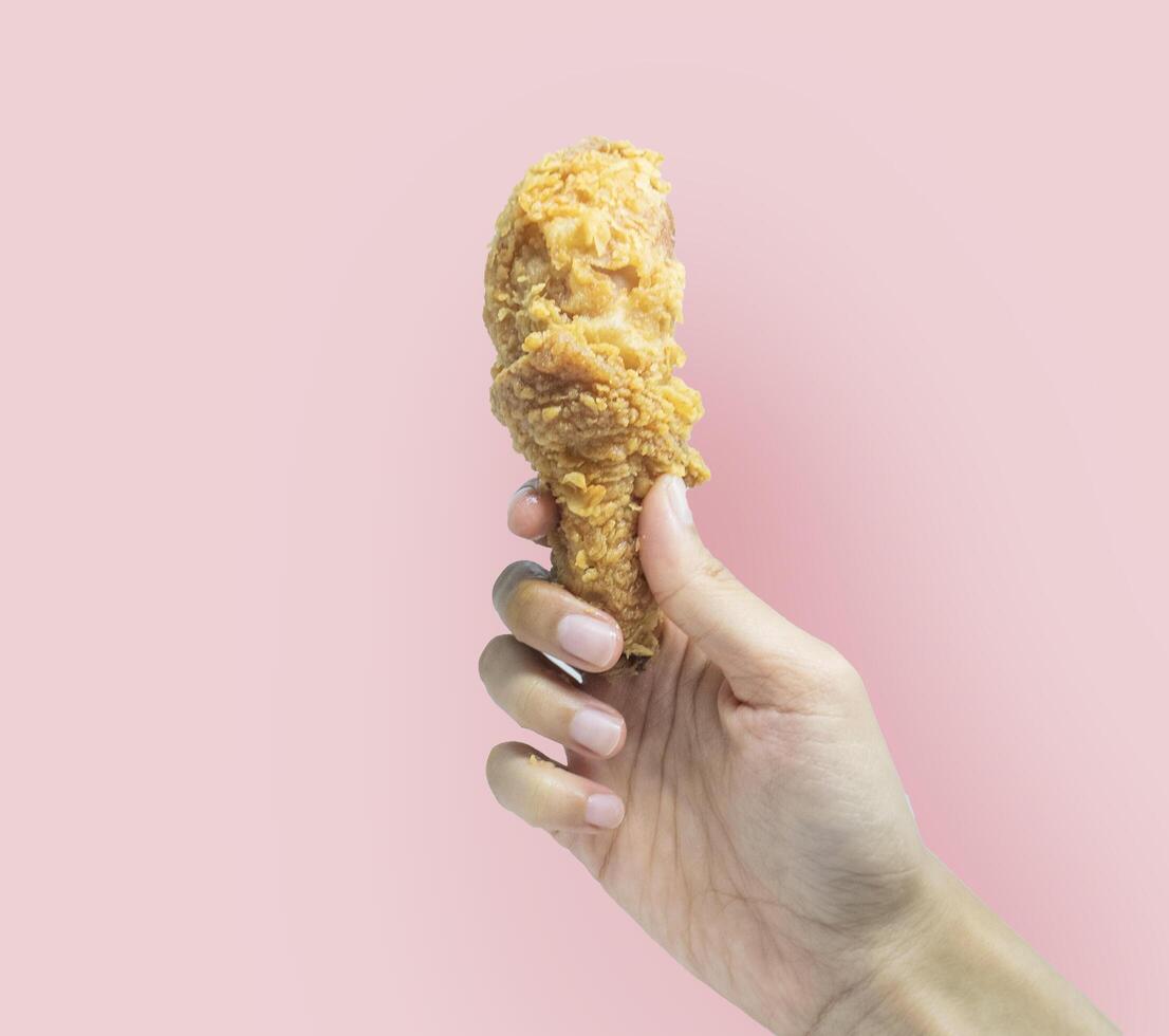 hand-held crispy fried chicken thighs photo