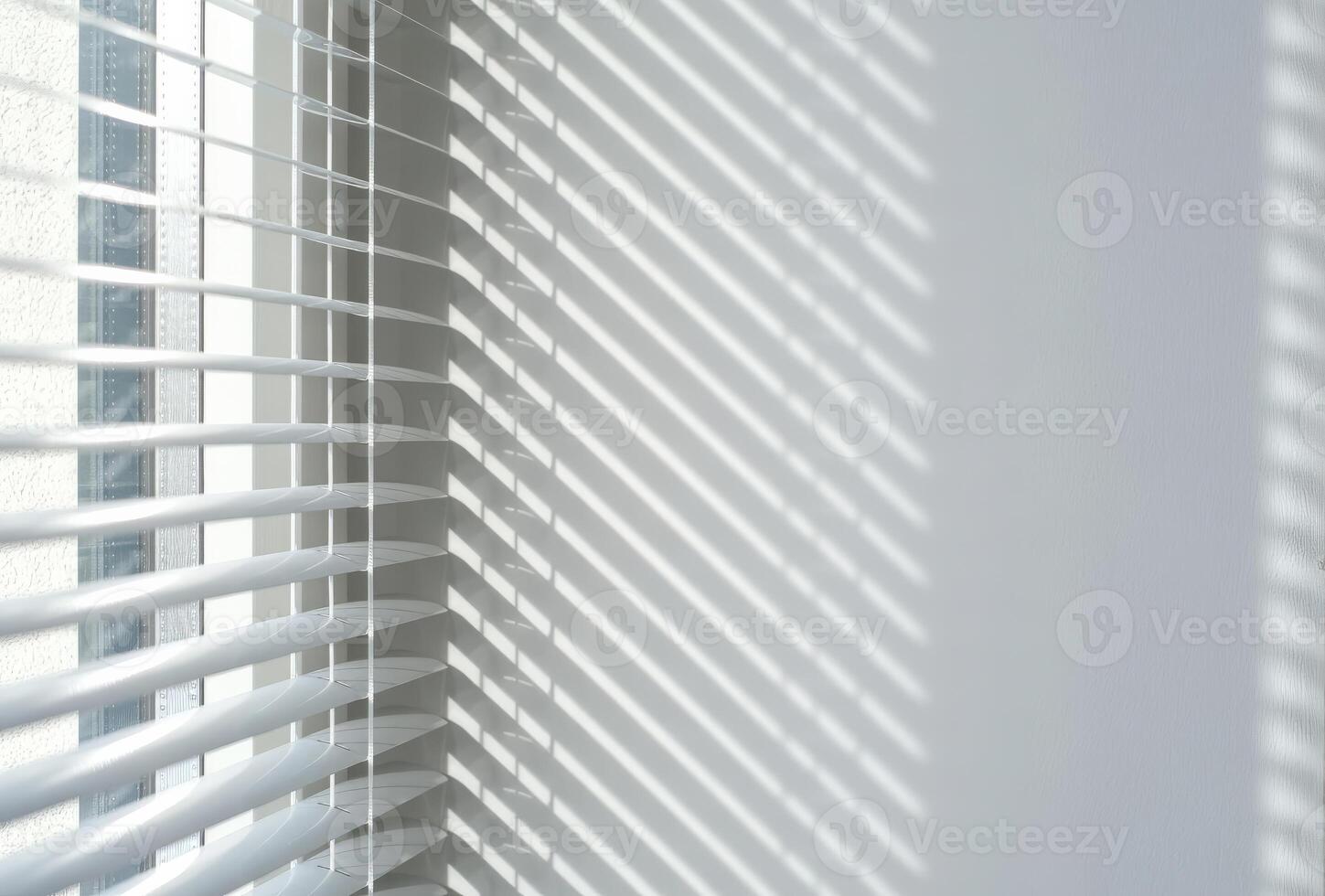 Sunlight casting striped shadows through white window blinds onto a clean wall photo