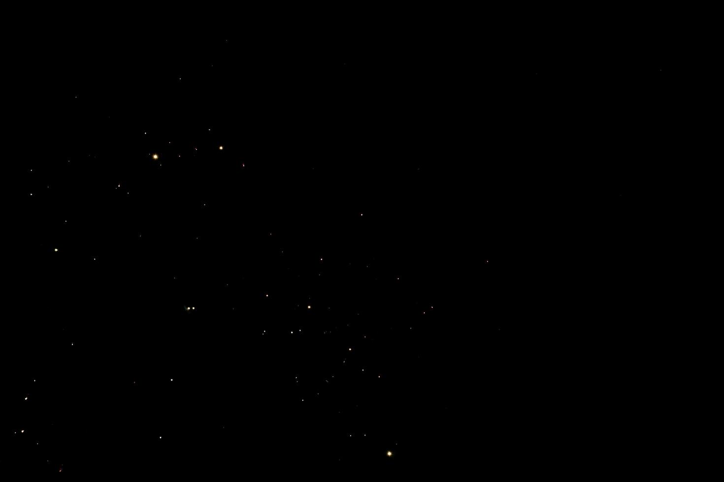 Small golden light particles scattered on dark background, dreamy night sky with sparkling stars photo