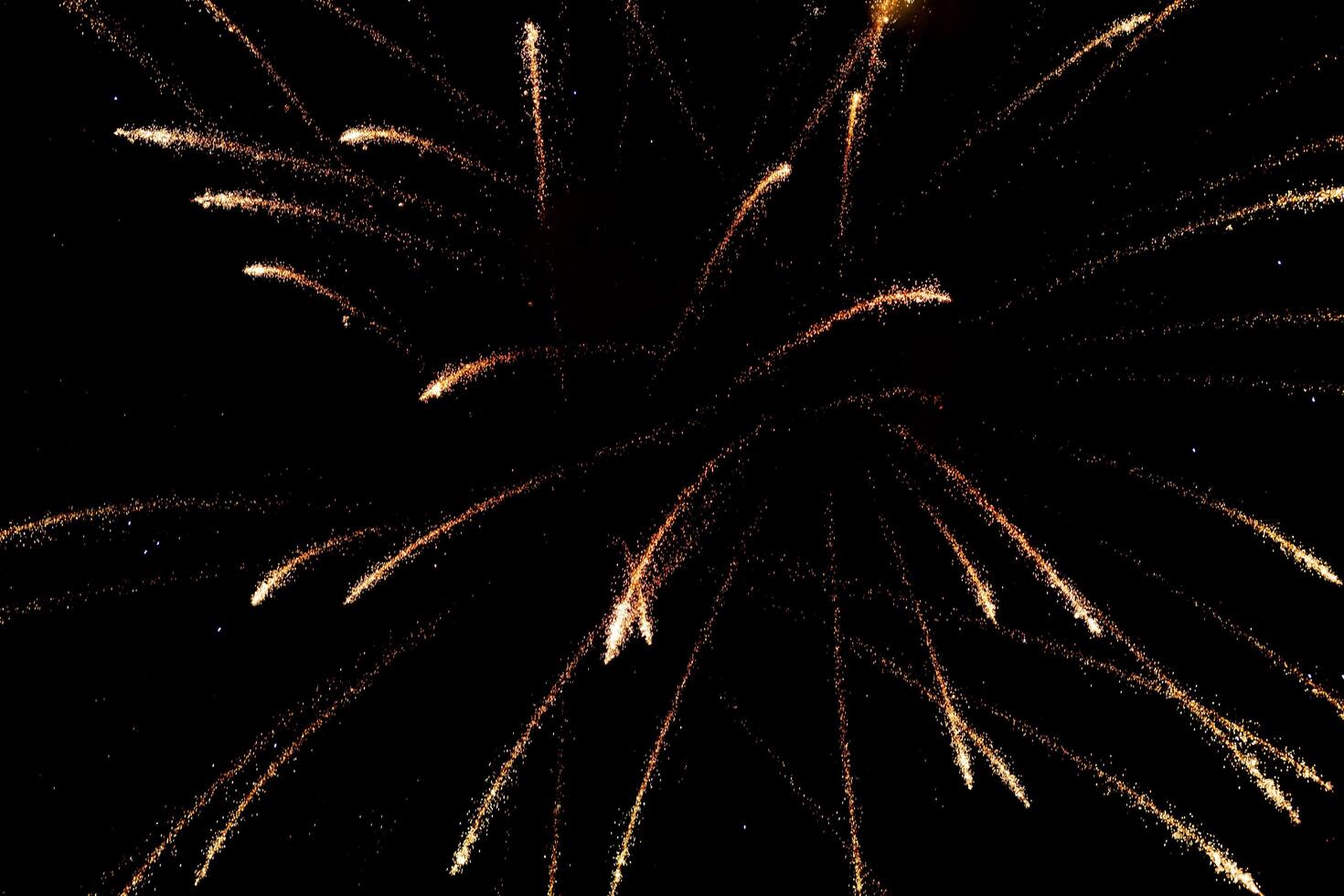 Spectacular golden fireworks show in night sky, shining sparks and trails perfect for celebration and background photo