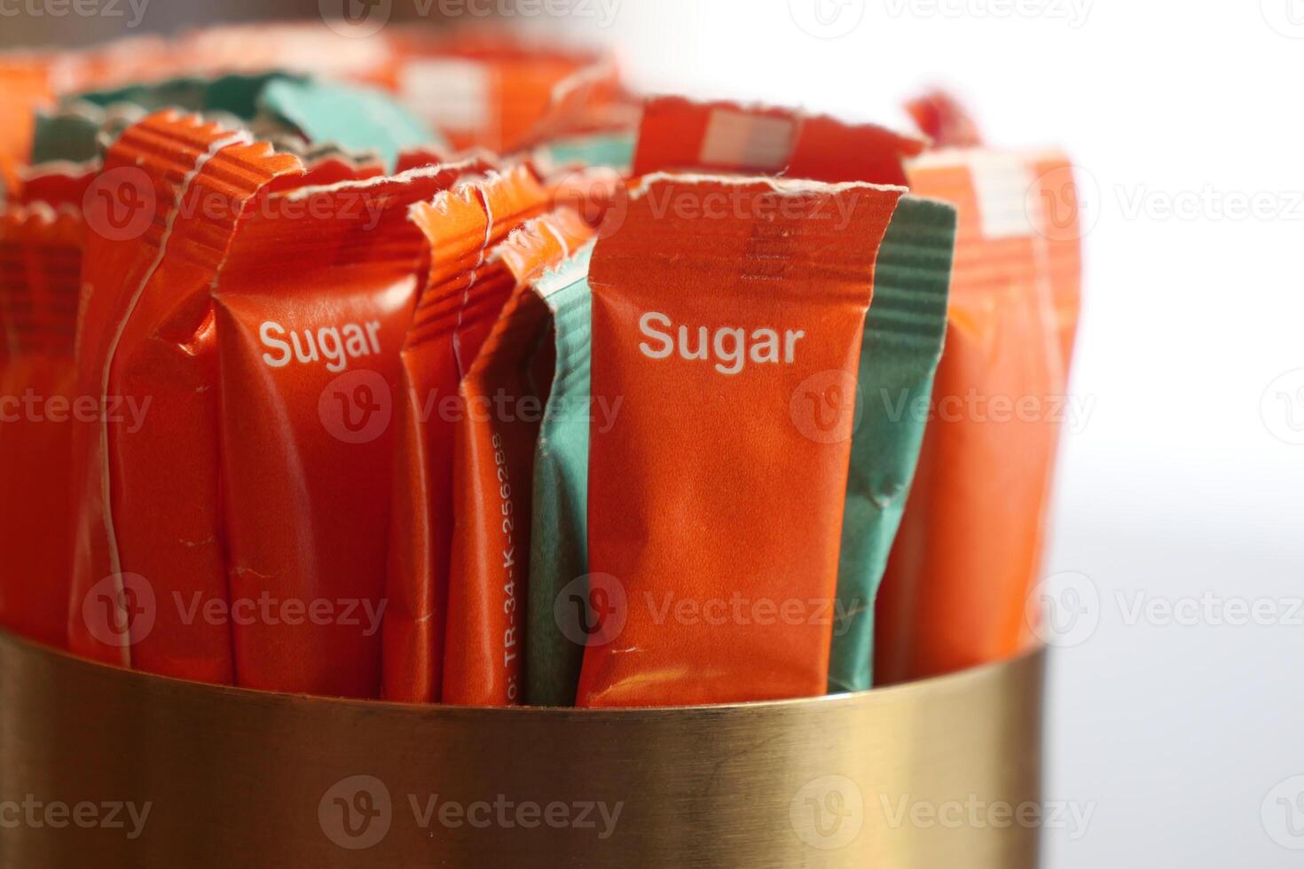 Sugar packets organized in a metal container at a cafe table photo
