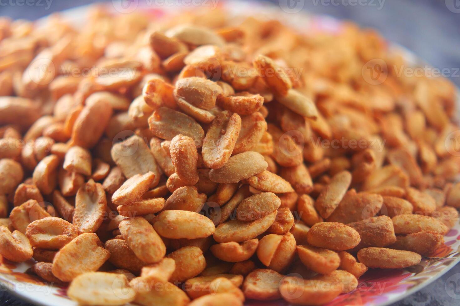 Roasted peanuts served on a colorful plate at a local market photo