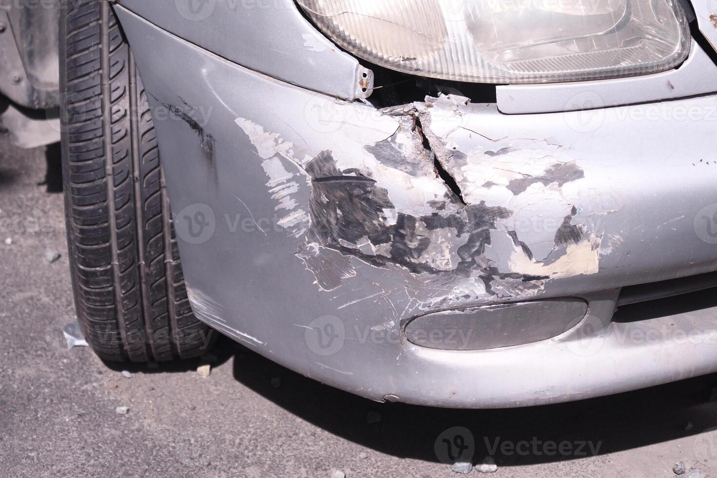 Car with significant damage parked on the roadside during daytime photo