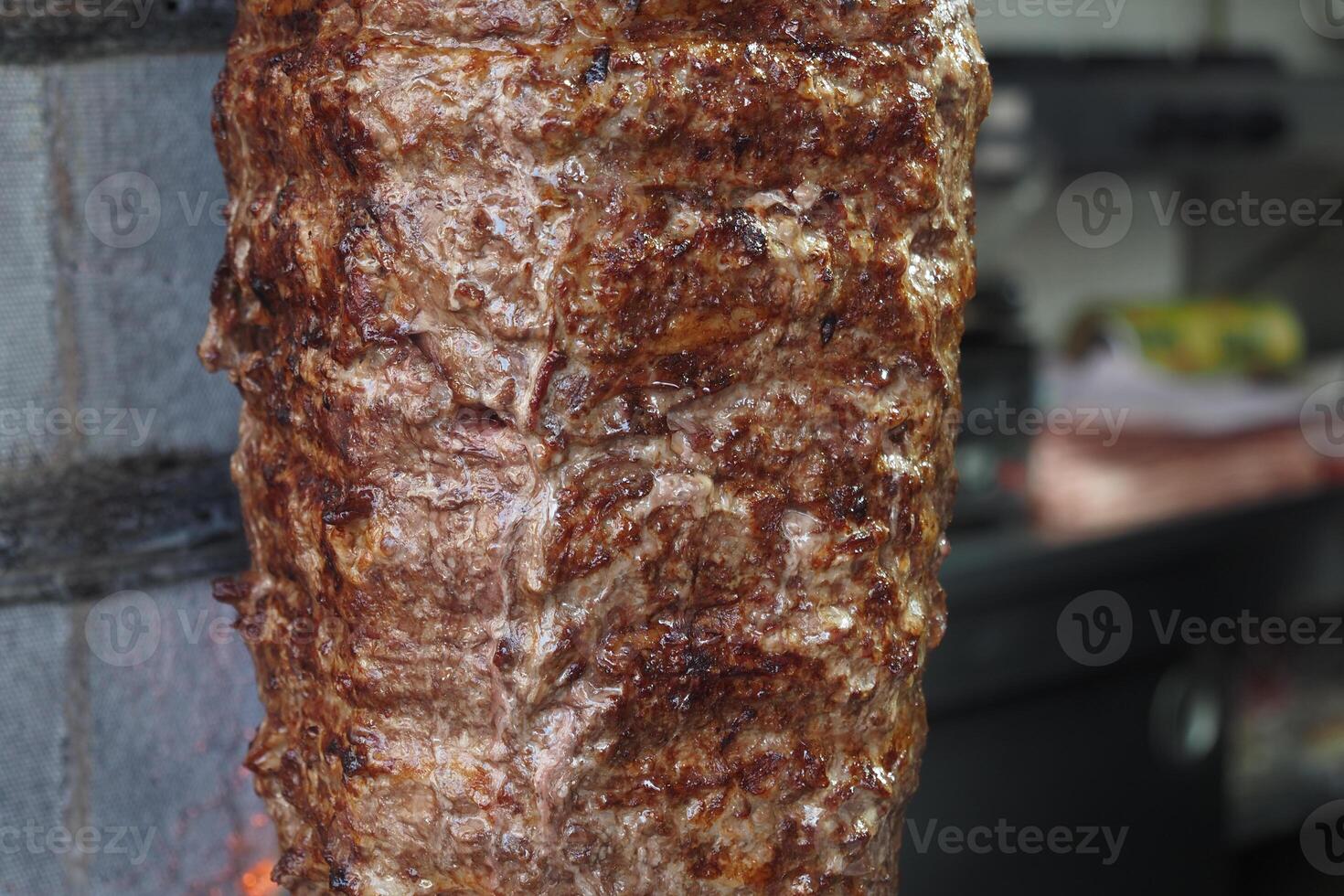Delicious meat roasting on a vertical grill at a street food stall photo