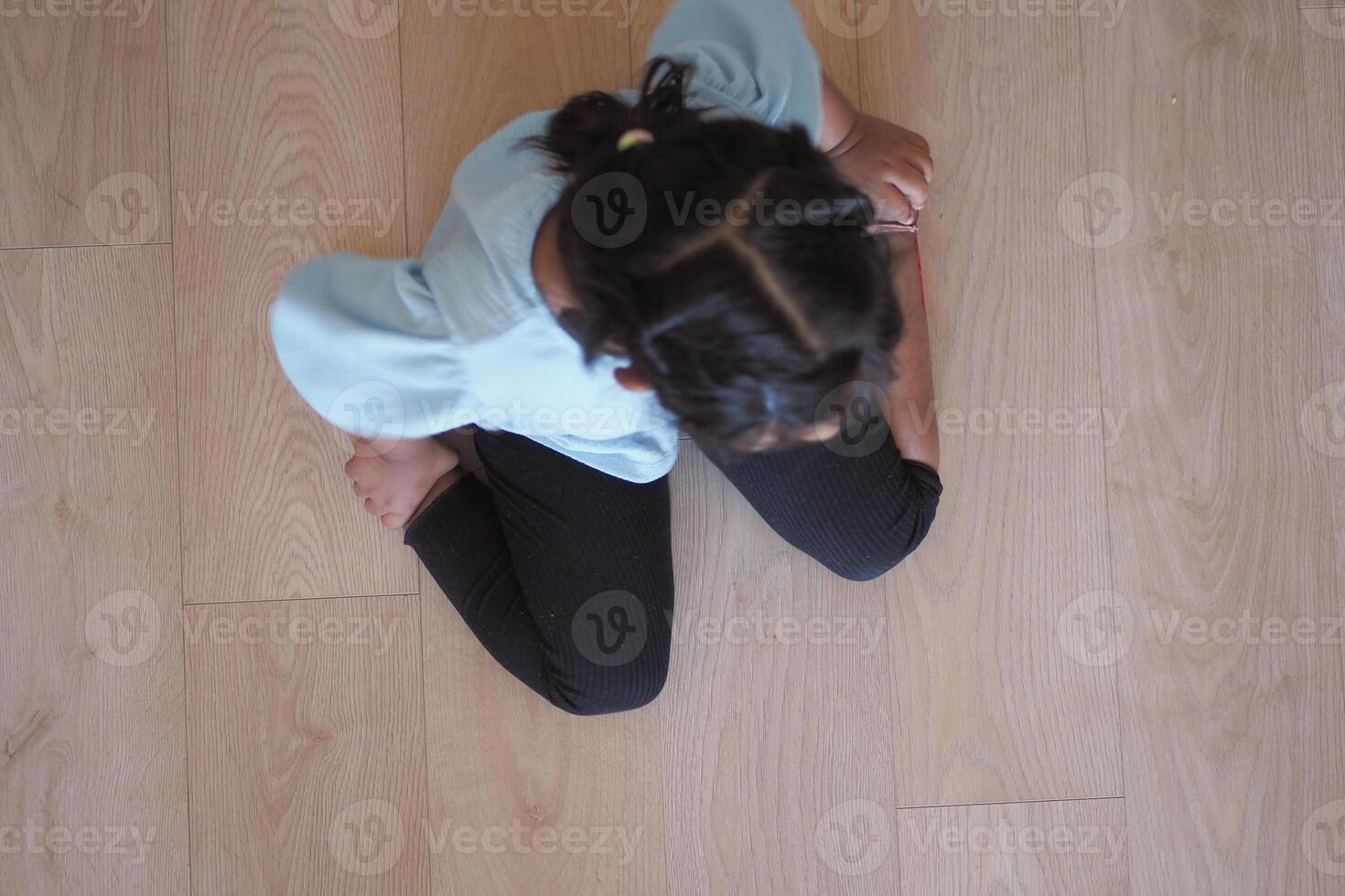 Child sitting on w shape on floor photo