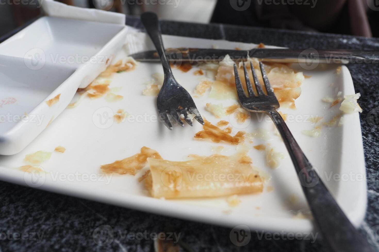 Empty plate with forks after a meal at a busy restaurant photo