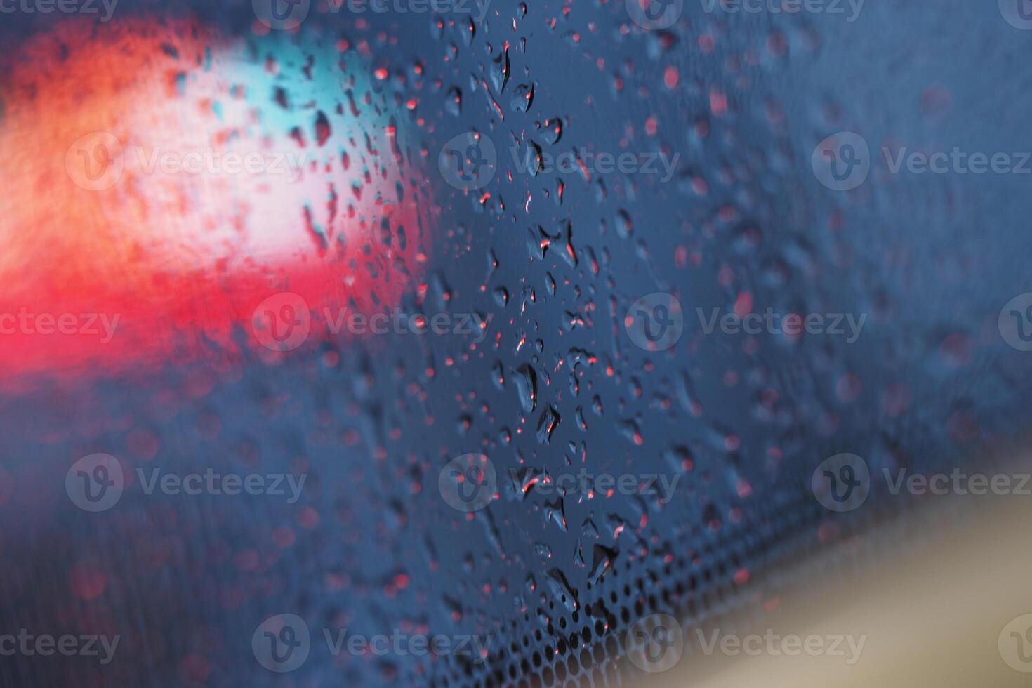 Raindrops on a window during a rainy evening in the city photo