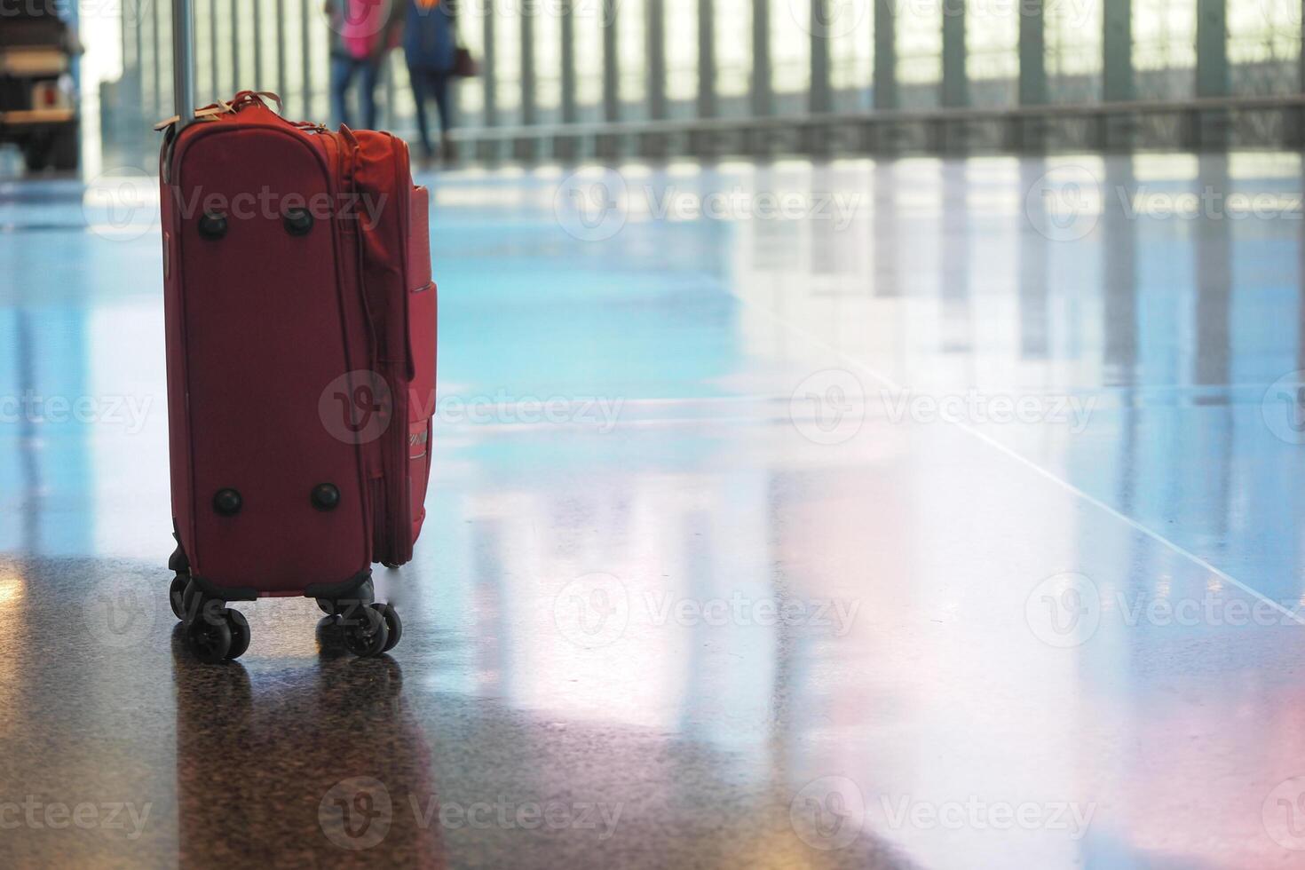 Lone suitcase waiting at airport terminal during busy travel hours photo