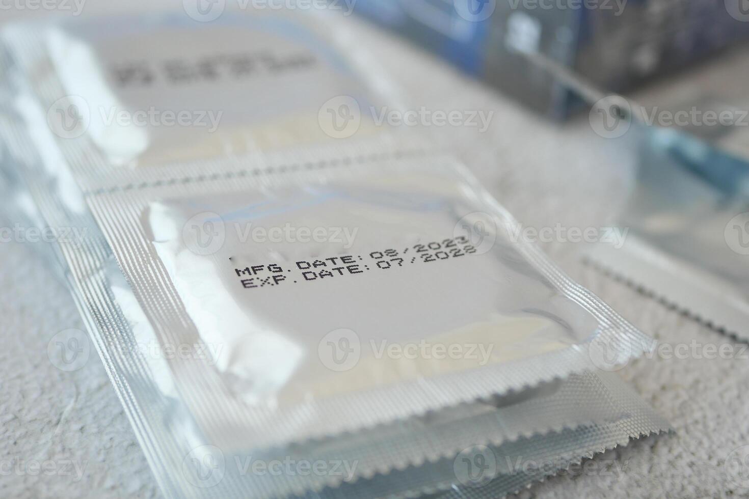 condom packet display manufacturing and expiration dates on surfaces photo