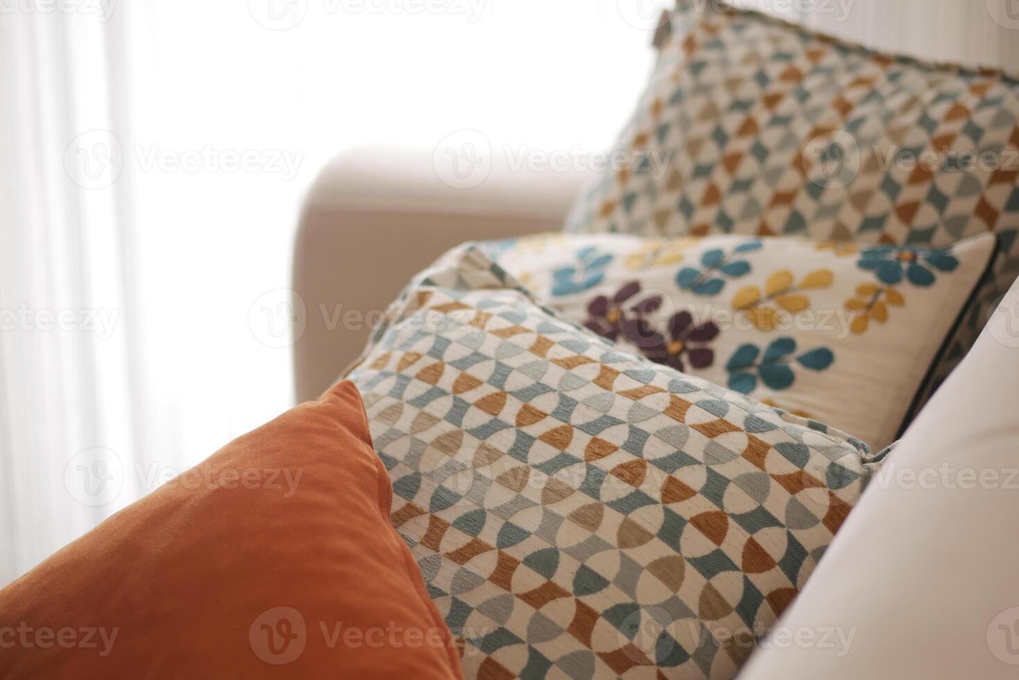 Decorative pillows arranged on a cozy couch in a bright room photo