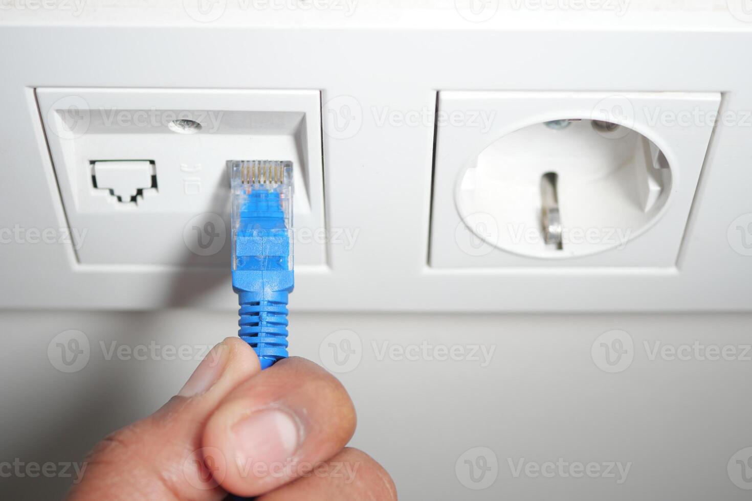 Connecting an ethernet cable to a wall socket in a modern setting photo