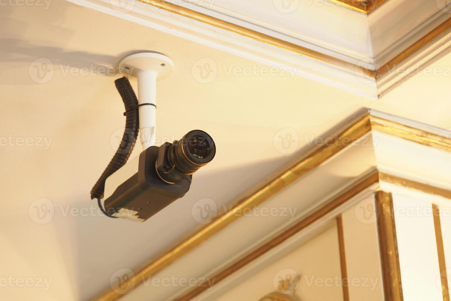 Surveillance camera installed on ceiling in a decorated interior photo