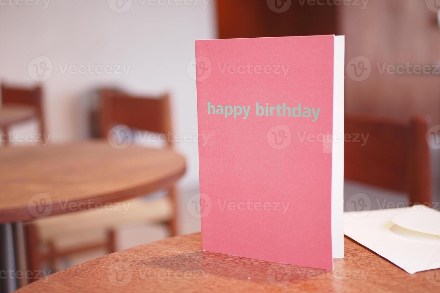 Happy birthday card on a table in a cozy cafe setting photo