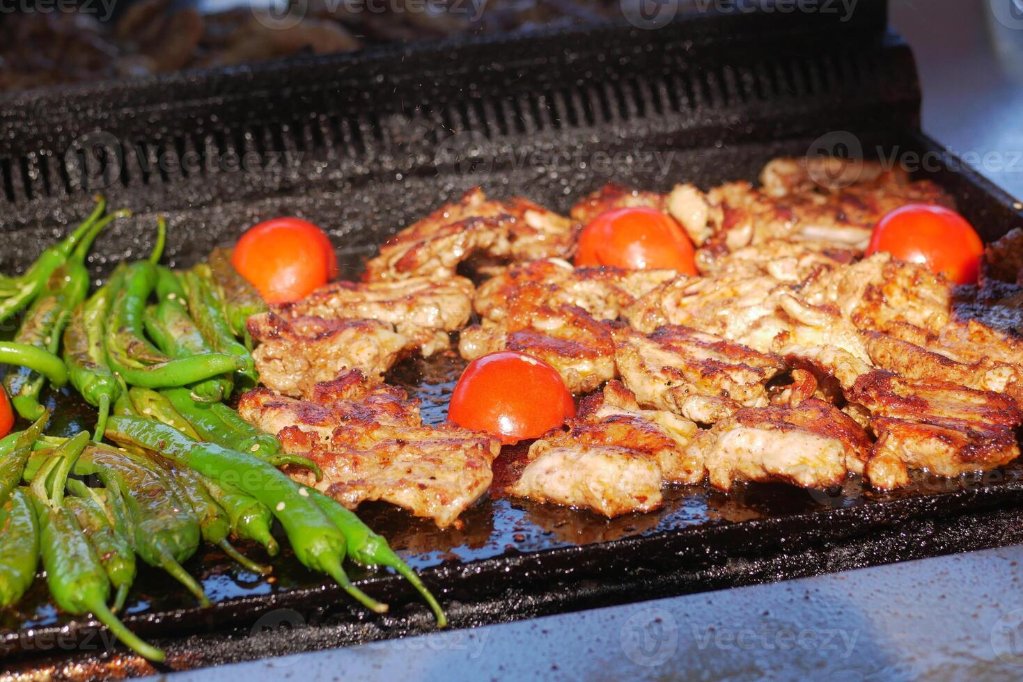 Grilling marinated meat and vegetables on a sunny outdoor barbecue photo