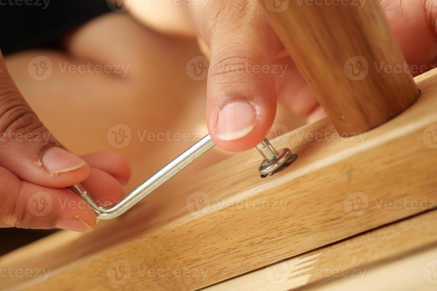 Fixing furniture with an Allen wrench at home photo