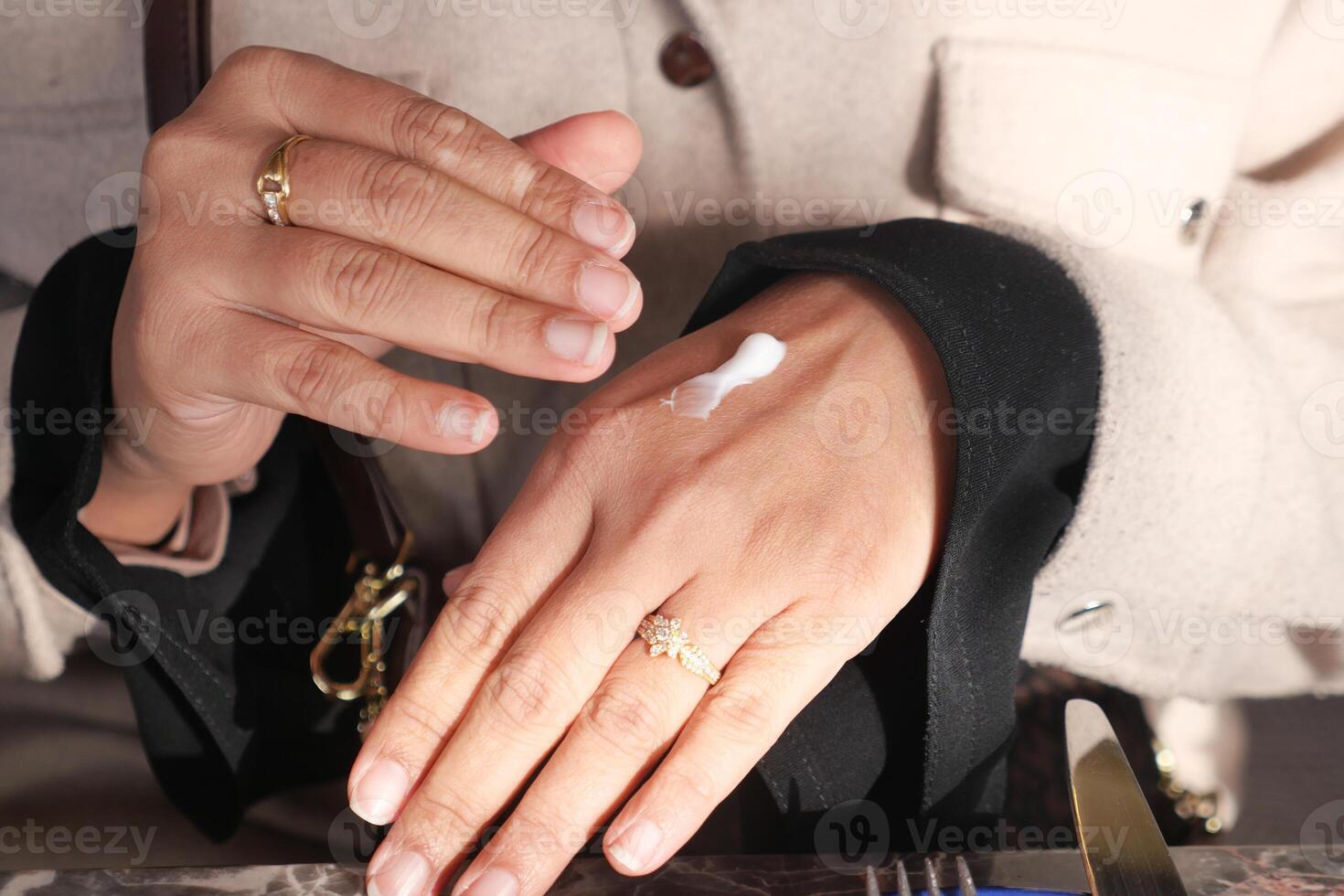 Applying moisturizing cream on hand during skincare routine photo