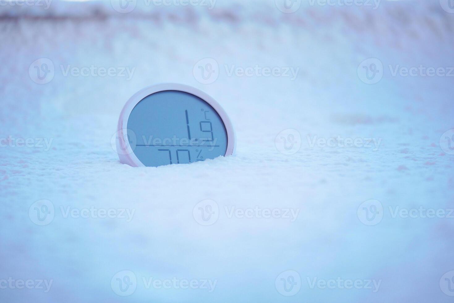 Digital thermometer shows low temperature in snow photo