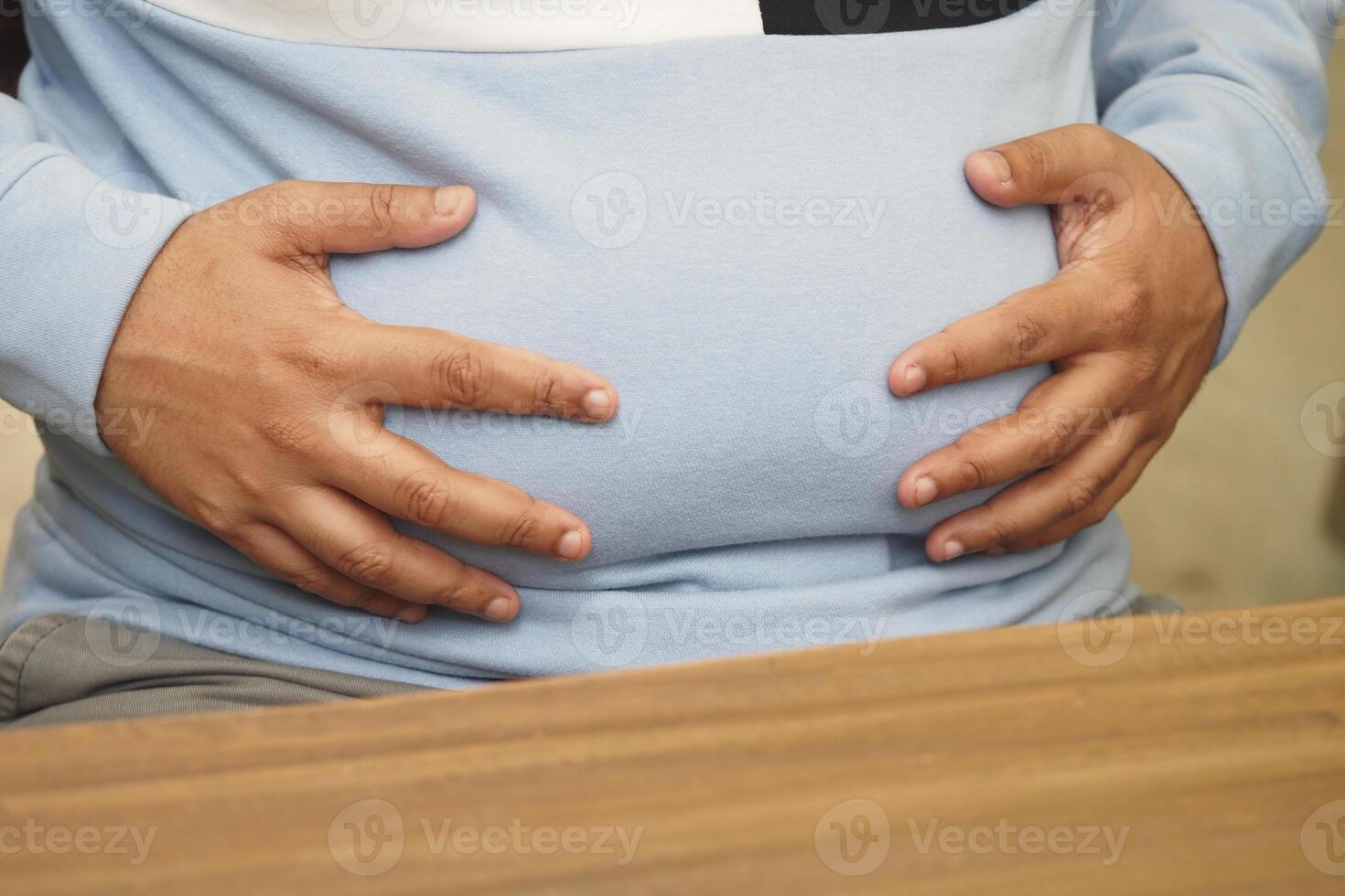 man holding his excessive belly photo