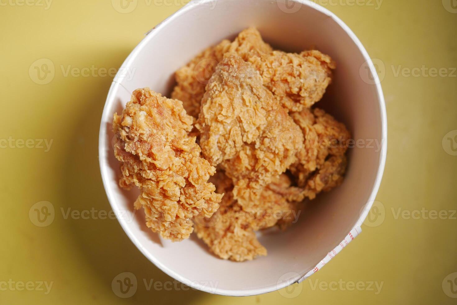 Crispy fried chicken served in a bowl on a yellow surface photo