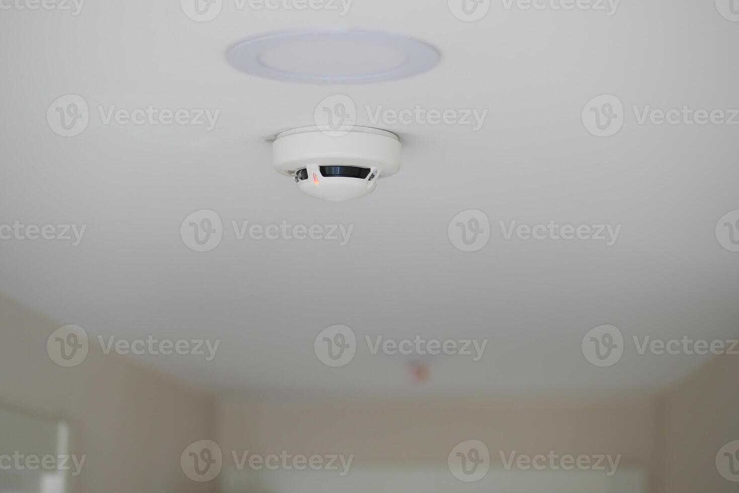 Smoke detector installed on a ceiling in a modern interior space photo