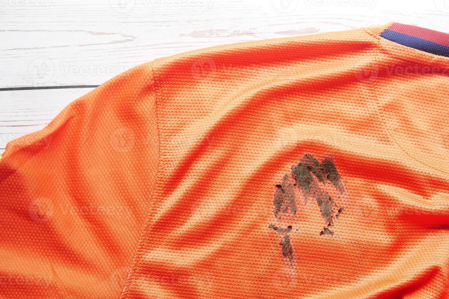 Orange jersey with dirt stain after an intense soccer match photo
