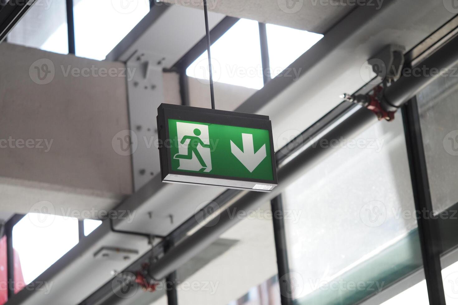 Emergency exit sign displayed inside a modern building photo