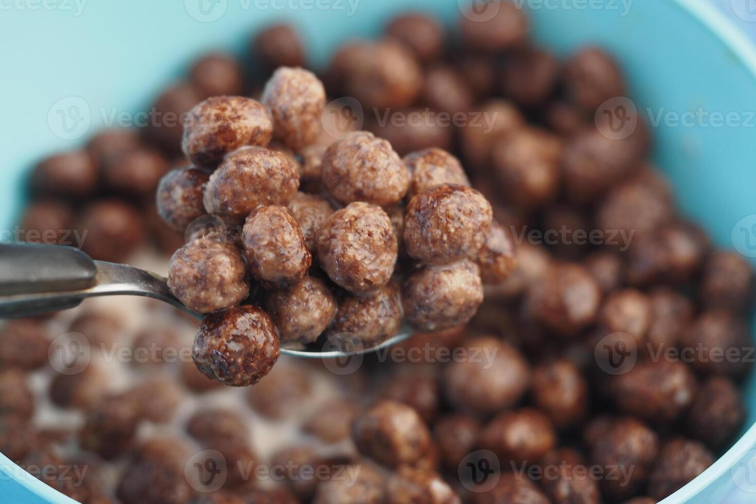 Delicious chocolate cereal balls in a blue bowl with milk photo