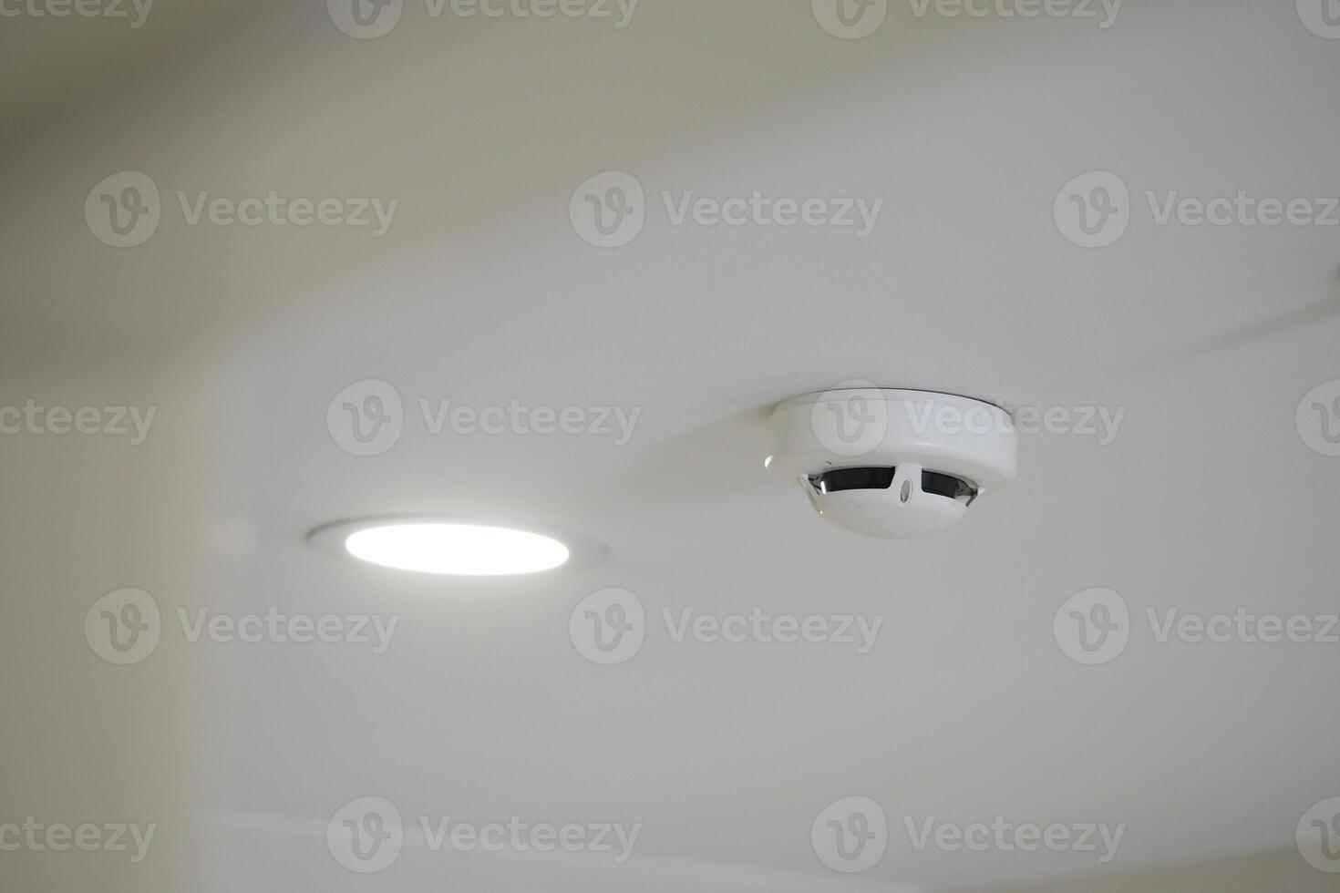 Smoke detector and ceiling light installed in modern room photo