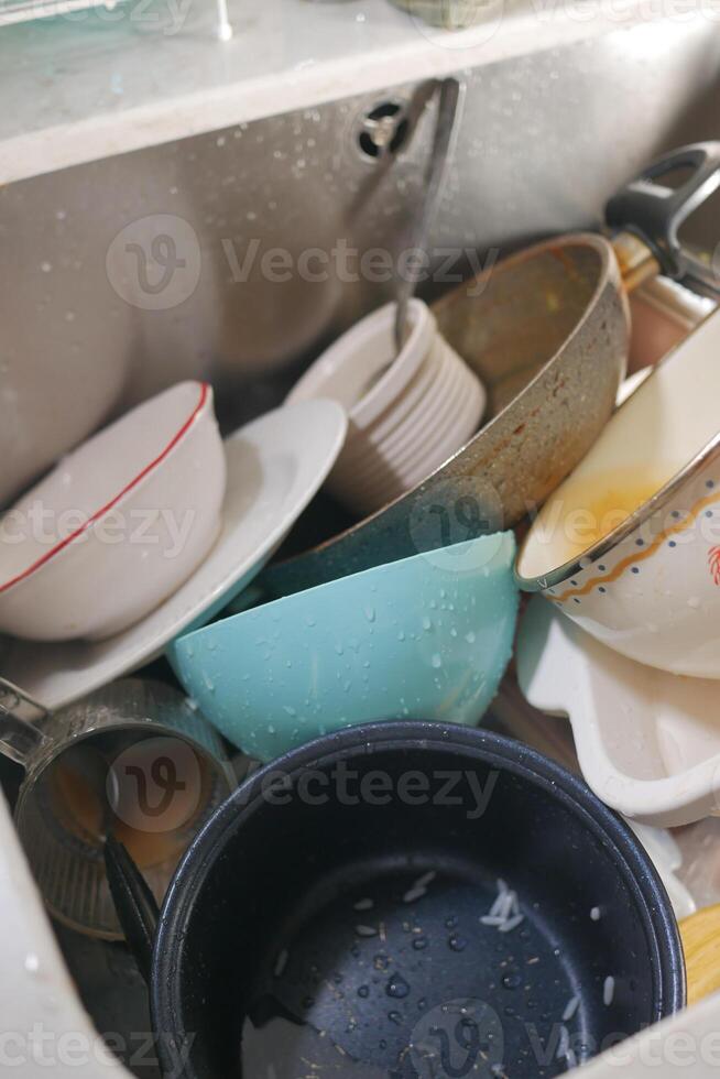 Dishes piled in a sink after a busy meal preparation photo