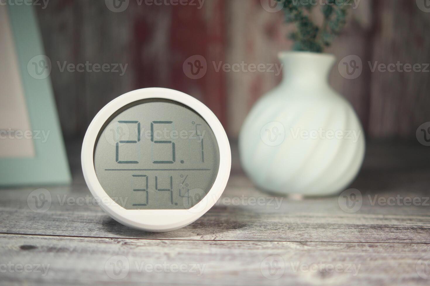 Temperature and humidity display on a wooden table indoors photo