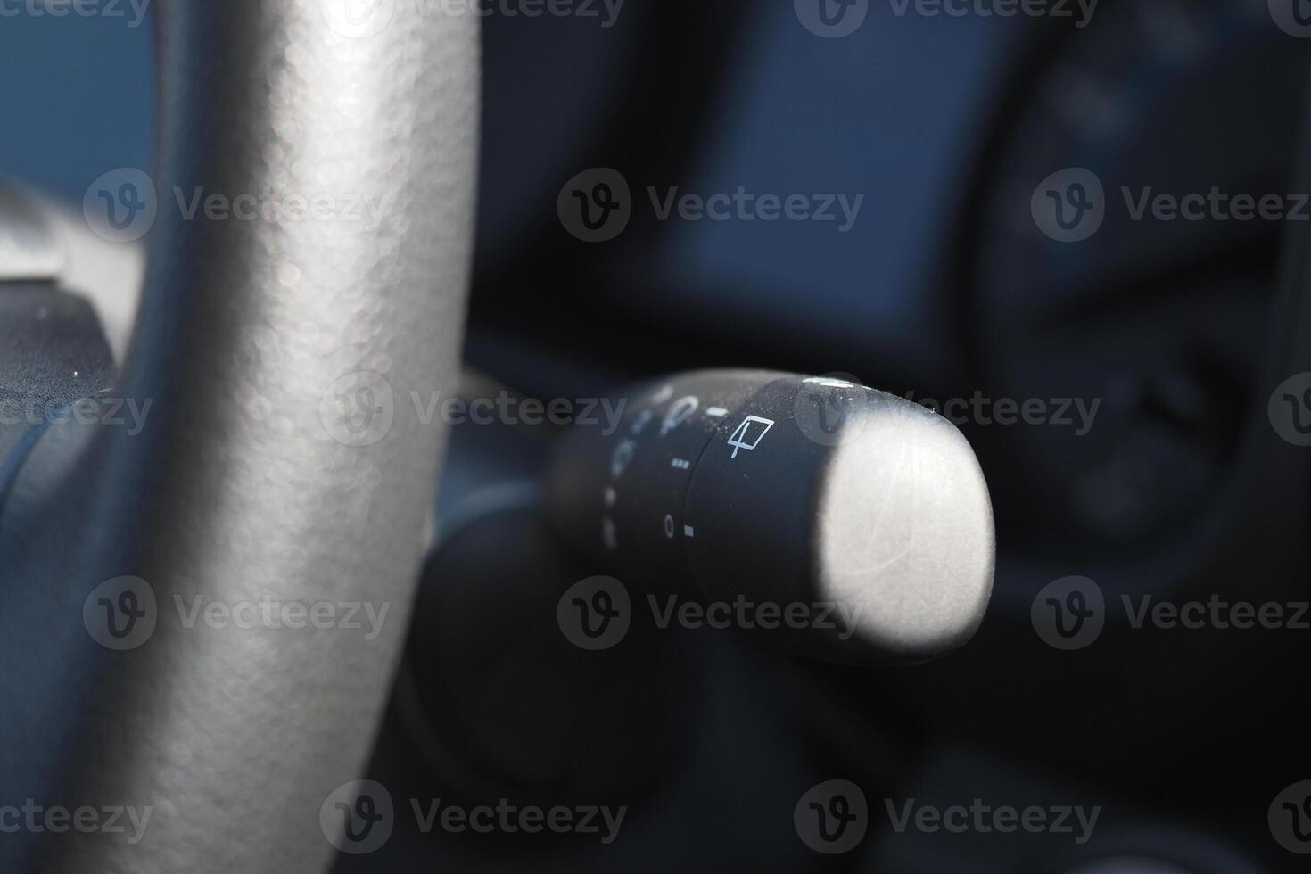 Details of a car's steering wheel controls in soft lighting photo