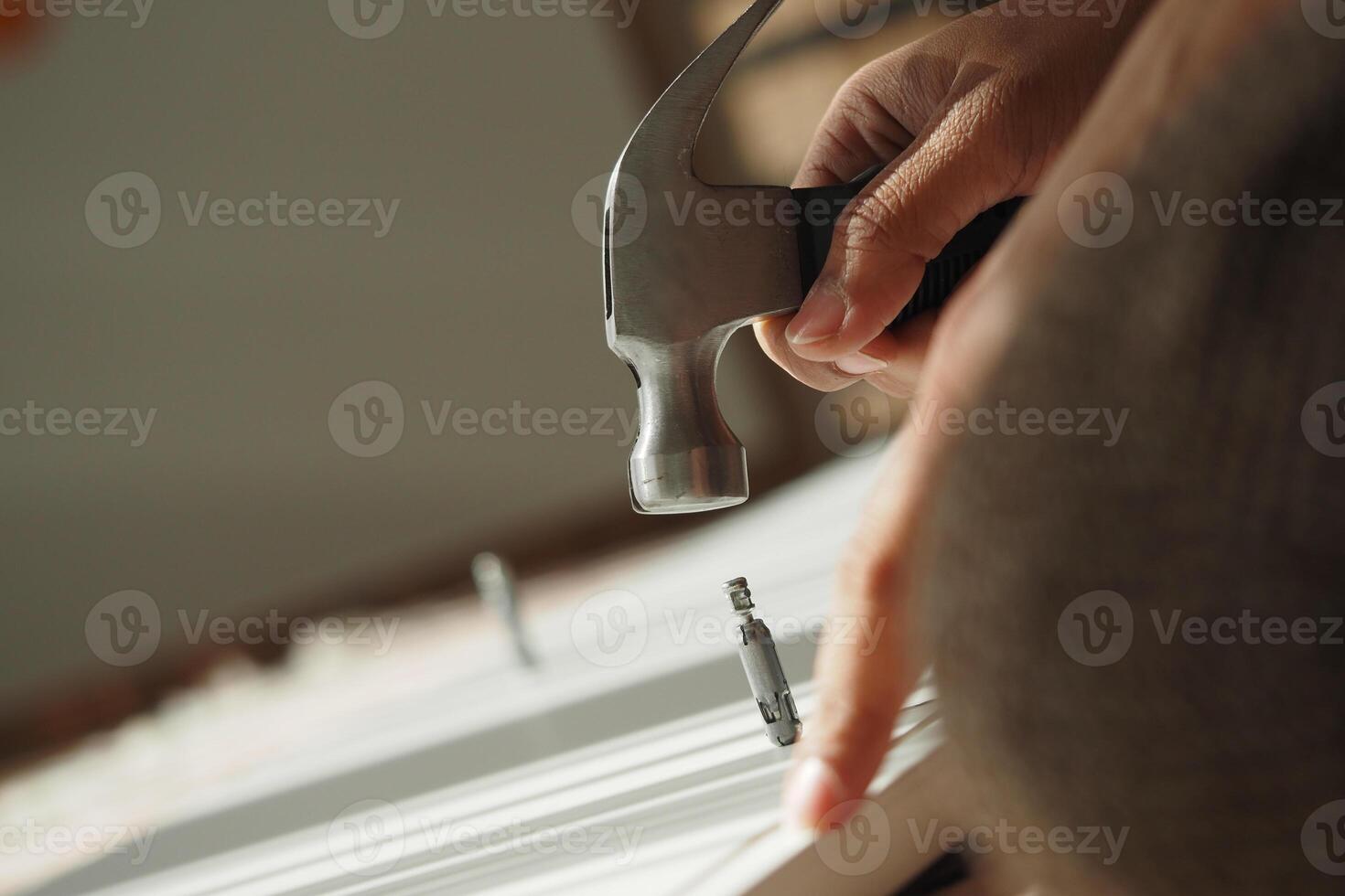 Hammering a nail into wood during a home improvement project photo
