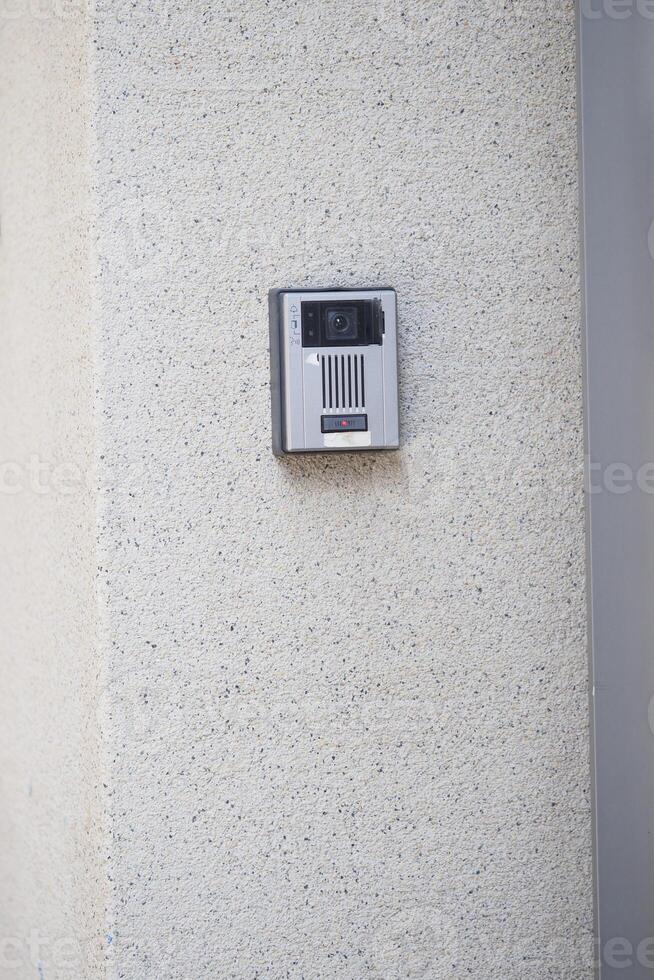 Security intercom installed on a textured wall outdoors photo