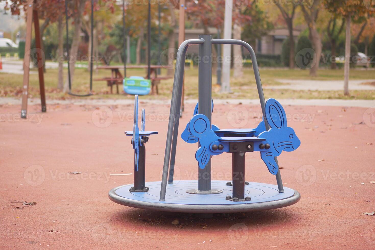 Bright blue rabbit-shaped merry-go-round in a park playground photo